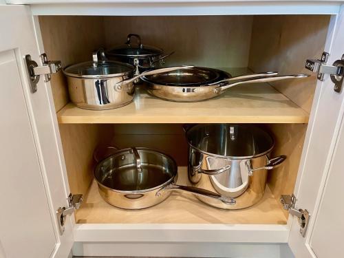 four pots and pans on a shelf in a kitchen at Downtown-Nomads-King Bed-Free Parking in Walnut Creek