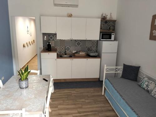 a kitchen and dining room with a table and a couch at La casa di mamma in Monopoli