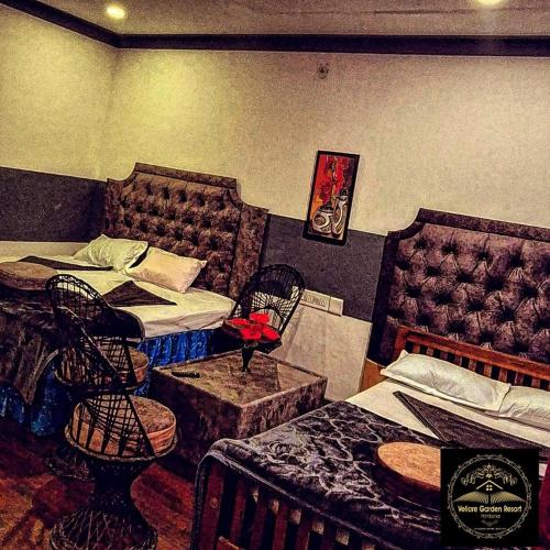 a bedroom with two beds and a table and chairs at Vellore Garden Home Stay in Idukki