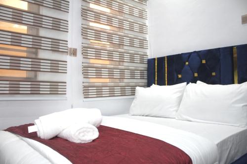 a bedroom with a white bed with towels on it at Flixx & Flixx Apartments - Eleyele Ibadan in Ibadan
