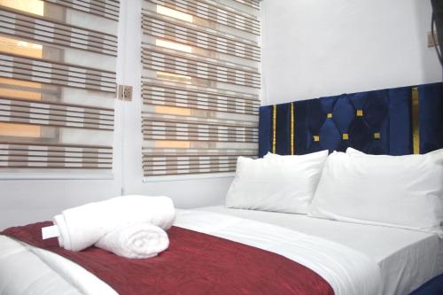a bedroom with a bed with white sheets and pillows at Flixx & Flixx Apartments - Eleyele Ibadan in Ibadan
