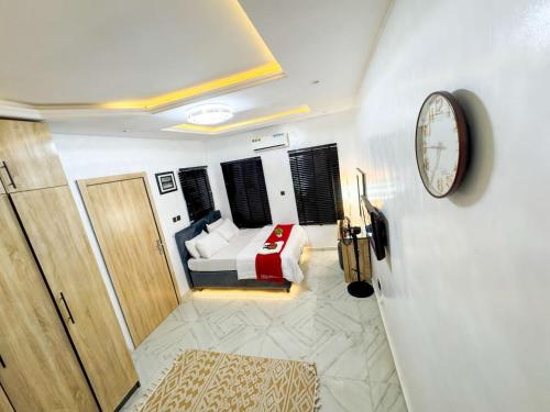 a bedroom with a bed and a clock on the wall at A Luxurious and Comfortable Studio Apartment in Ikeja