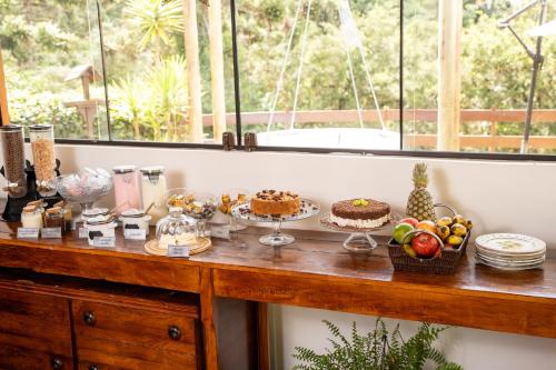 a table with cakes and other food on it at Pousada Apple House Campos do Jordao in Campos do Jordão