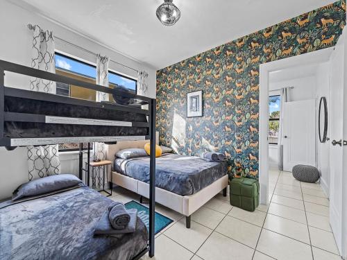 a bedroom with two beds and a wall with floral wallpaper at Villa Tranquillo Calle Ocho Pool & Hot Tub in Miami