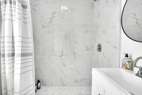 a white bathroom with a shower curtain and a sink at Villa Tranquillo Calle Ocho Pool & Hot Tub in Miami