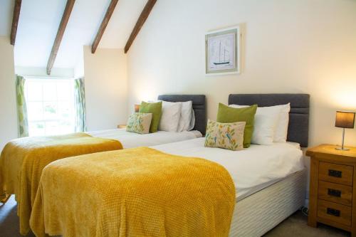 two beds sitting next to each other in a room at The Manor House in Holyhead