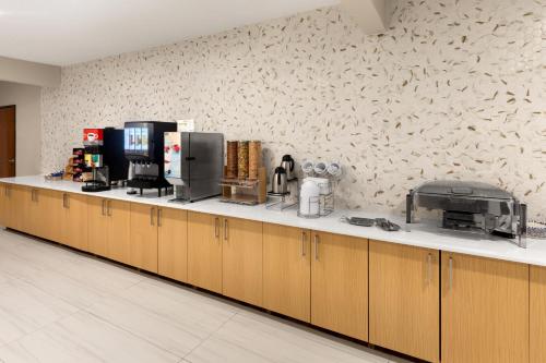 a kitchen with wooden cabinets and a white counter top at Wingate by Wyndham College Station South in College Station
