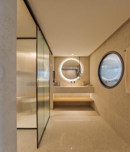 a bathroom with a round mirror and a sink at MACAM Hotel in Lisbon