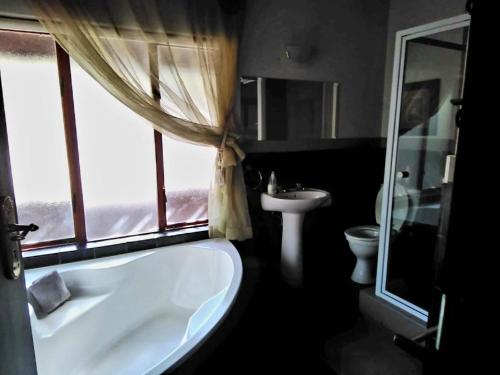 a bathroom with a tub and a sink and a window at Mafuta Lodge - Mabalingwe Nature Reserve in Warmbaths