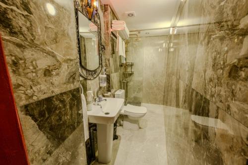 a bathroom with a sink and a toilet and a mirror at Riad Diamant De Fes in Fès