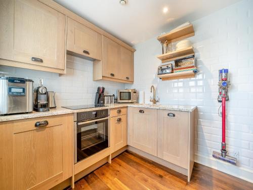 a small kitchen with wooden cabinets and appliances at Lundin Links - Ukc6916 in Turnberry