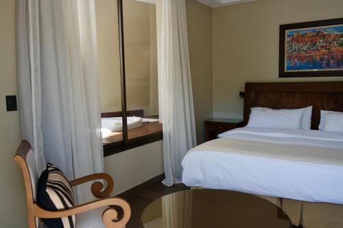 a bedroom with a bed and a mirror and a chair at Hotel Almería in Salta