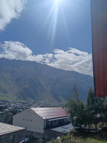 a view of a building with mountains in the background at My house in Stepantsminda
