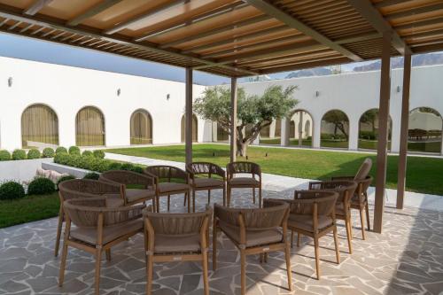 a patio with a long table and chairs at Ivory House Resort - Ophiolite in Hatta