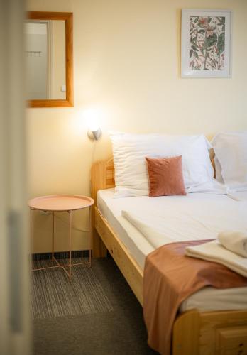a room with two beds and a table and a mirror at Regia Panzió in Halászi