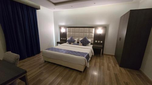 a bedroom with a bed with blue pillows on it at Marwa Residance in Jeddah