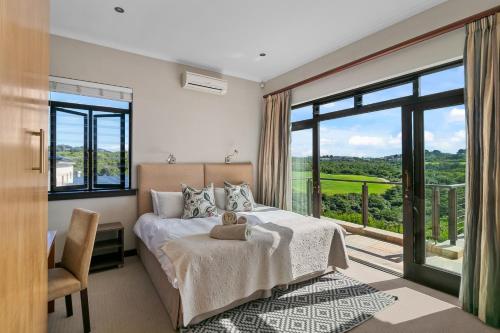 LinksView at Pezula في كنيسنا: غرفة نوم بها سرير ونافذة كبيرة