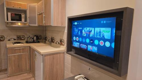 a kitchen with a large flat screen tv on the wall at Marwa Residance in Jeddah
