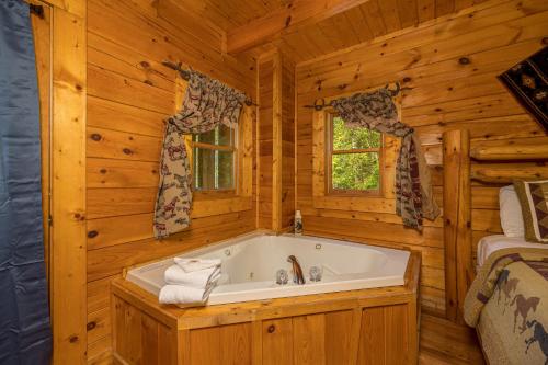 a bathroom with a tub in a log cabin at Dukes Den by American Patriot Getaways in Cartertown