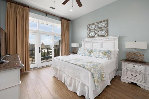 a bedroom with a white bed and a large window at Sea Point #303 in Saint Simons Island