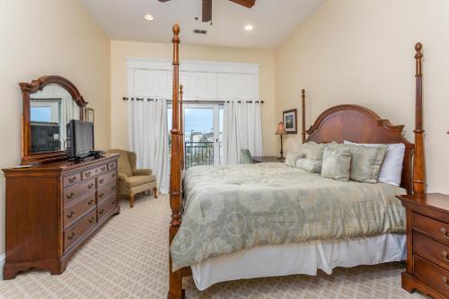 a bedroom with a bed and a television and a dresser at Sea Point #304 in Saint Simons Island