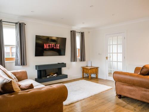 a living room with two couches and a fireplace at Fir Tree Lodge in Sewerby
