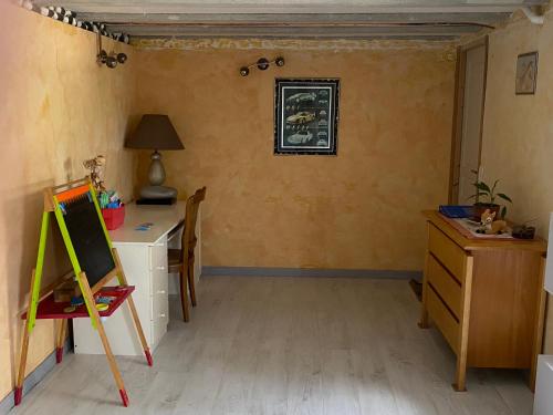 a room with a desk and a painting on the wall at La Maison Provençale in Unieux