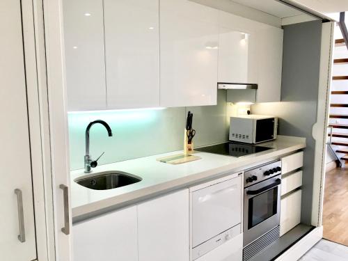 a white kitchen with a sink and a microwave at Panoramic Suites By VALENCIAFLATS EU in Valencia