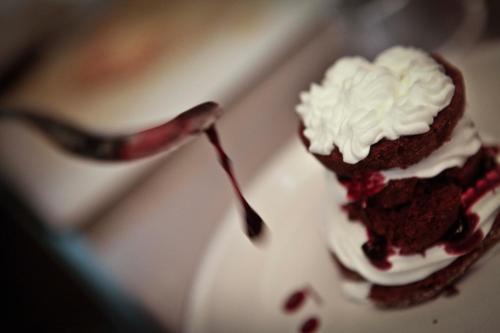 a piece of chocolate cake with whipped cream and a spoon at Abas Ristorante Pizzeria Affittacamere in Ales