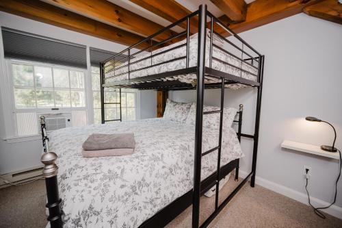 a bedroom with a bunk bed in a room at Cozy Condo, Minutes from Sunday River in Bethel