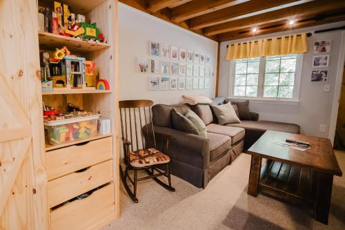 a living room with a couch and a table at Cozy Condo, Minutes from Sunday River in Bethel