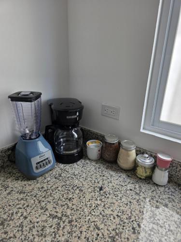 a blender sitting on a counter next to some jars at Casa Moderna en Fraccionamiento in Caucel