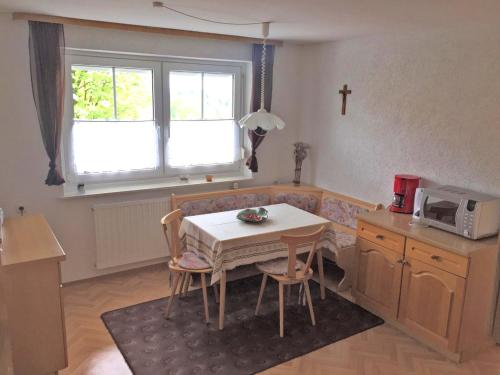 a small kitchen with a table and a microwave at Gartenwohnung Gößweinstein in Gößweinstein