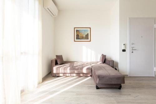 a bedroom with a bed and a ottoman at OASI TRILOCALE DOPPI SERVIZI- Rho Fiera - Milano Como Lago Malpensa in Cesate