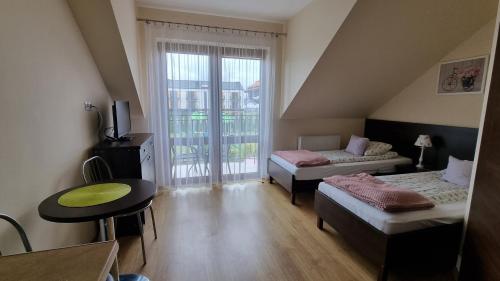 a small room with a bed and a table and a window at VILLA KORA in Rowy