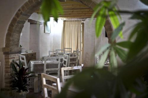 a dining room with white chairs and tables at Abas Ristorante Pizzeria Affittacamere in Ales