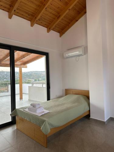 Un dormitorio con una cama y una ventana grande. en Vana's Apartments, en Sarandë