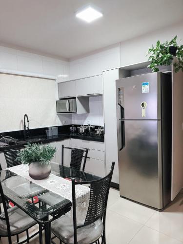 a kitchen with a table and a stainless steel refrigerator at APTO 100% Climatizado - Experiência Premium - Único na Cidade - Garagem Privativa p/ carros ñ atende caminhonetes. in Três Lagoas