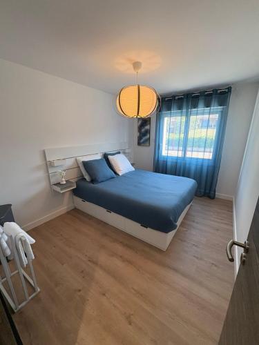 Saint-Clair-du-RhôneにあるLe luxe au pied du pilat - 6 voyageursの青いベッドと窓のある寝室