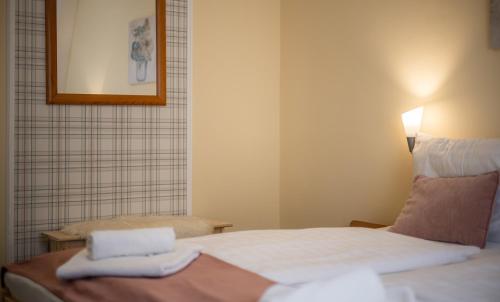 a room with a bed with two towels on it at Regia Panzió in Halászi