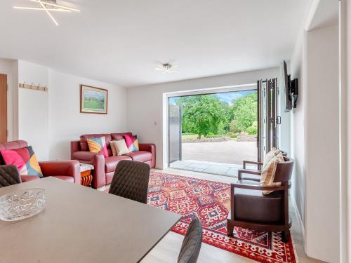 a living room with a table and chairs and a sliding glass door at Uk46790 - Orchard Retreat in Woolaston