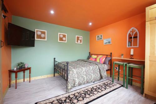 a bedroom with a bed and an orange wall at Georgias Gate Studio Cottage - Sleeps 4 & Pets Ok in Errill