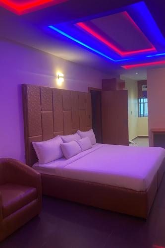 a bedroom with a large bed with purple lighting at Beamgate Hotels & Apartments, Abak Rd, Uyo in Uyo
