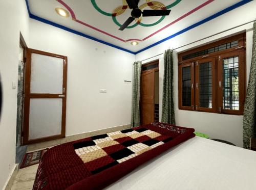 a bedroom with a checkered bed with a ceiling at maa kalishila home stay in Ukhimath