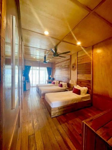 a bedroom with two beds and a ceiling fan at Nusakuya Resort in Semporna