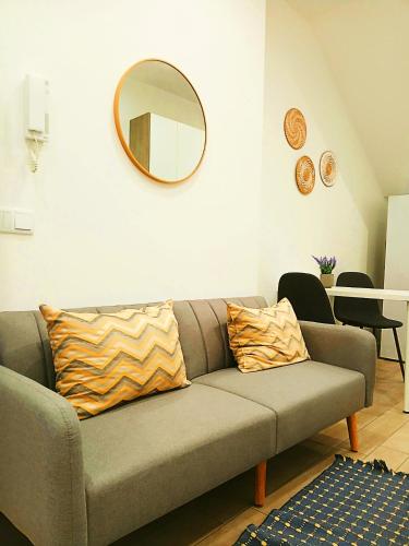 a living room with a couch and a mirror at Casa do Hilário in Viseu