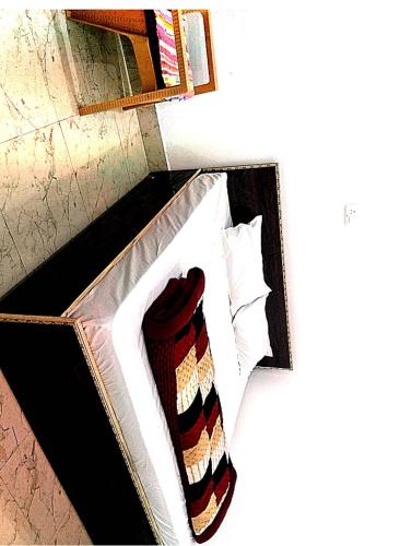 a box with a tie on top of a bed at maa kalishila home stay in Ukhimath