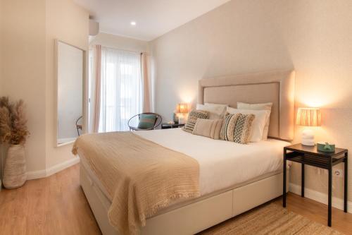 1 dormitorio con 1 cama grande, 2 mesas y ventana en Sea la Vie by LovelyStay, en Matosinhos