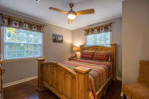 a bedroom with a wooden bed and a ceiling fan at Easy Livin by American Patriot Getaways in Waldens Creek