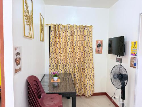 a dining room with a table and a red chair at budget transient house near sm Lucena 6pax in Lucena